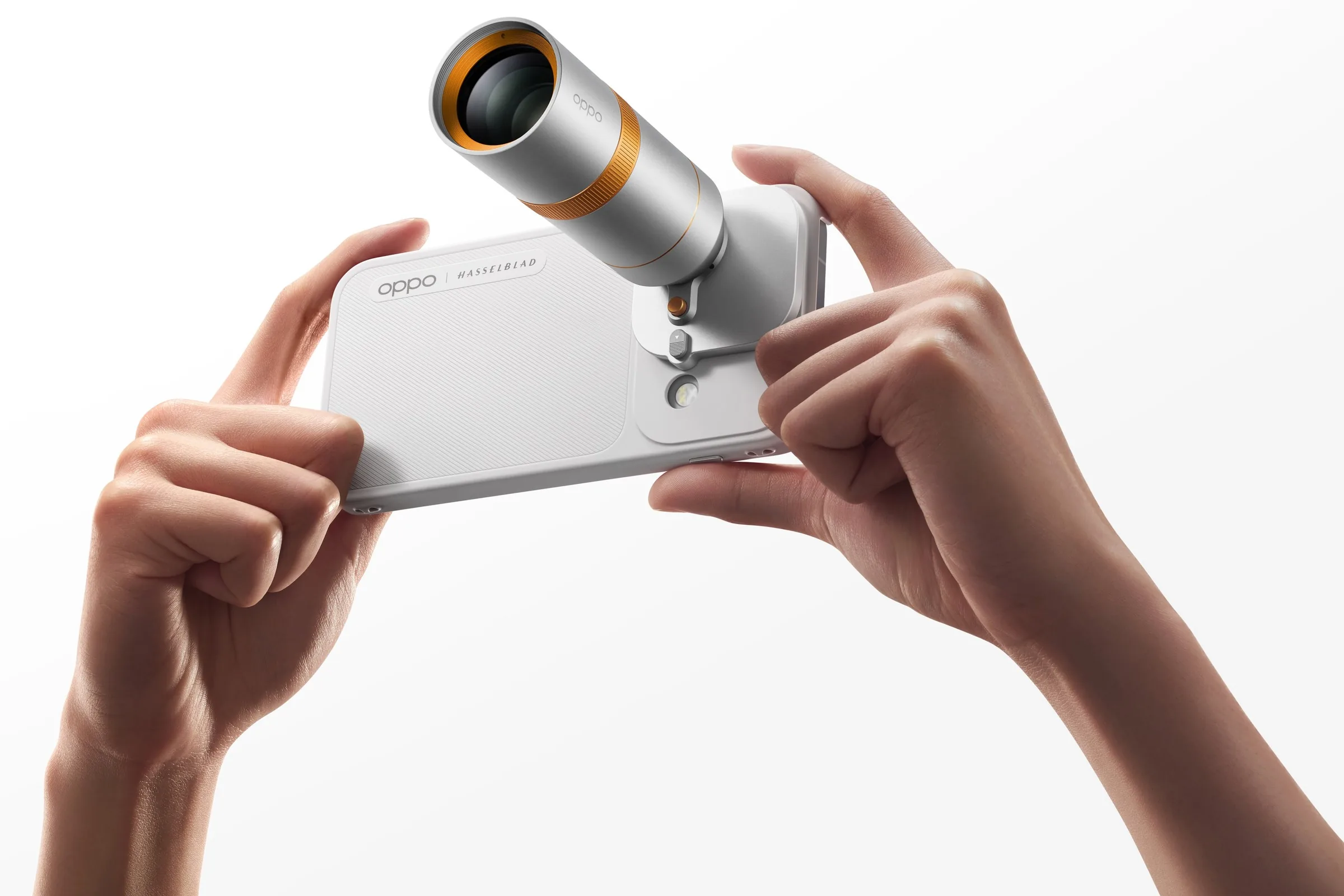 Two hands holding a white Oppo phone sideways in a case with a long silver and orange Hasselblad teleconverter lens attached over its camera