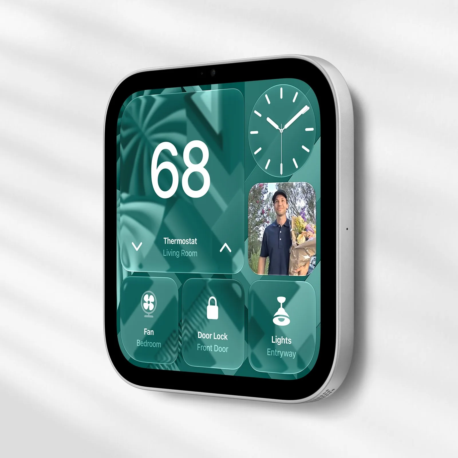 A wall-mounted Apple HomeView with a square screen showing a thermostat, a doorbell camera feed and buttons for a fan, a door lock and lights