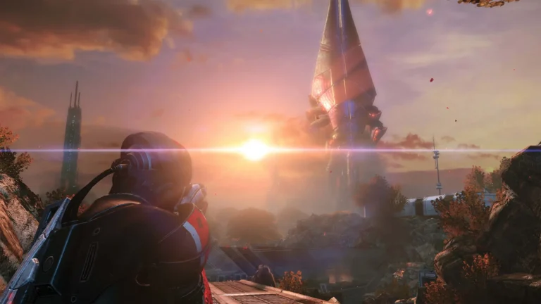 An armored soldier, seen from behind, looks toward a towering alien ship at sunset in Mass Effect Legendary Edition
