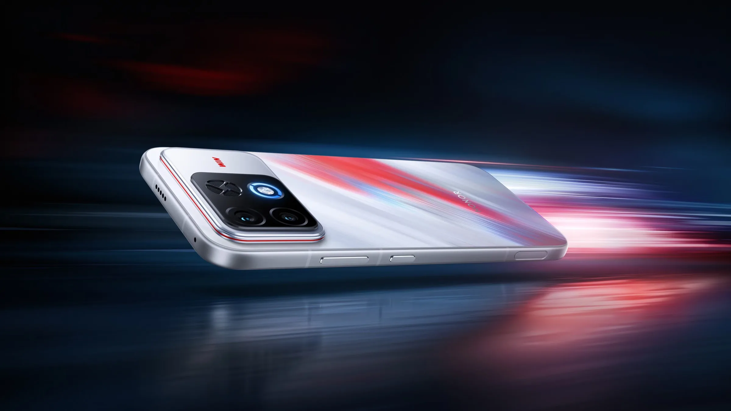 A white Honor Win2 with red and blue streaks across its back, lying at an angle, its camera block showing two lenses, an X-shaped grille and a glowing blue ring