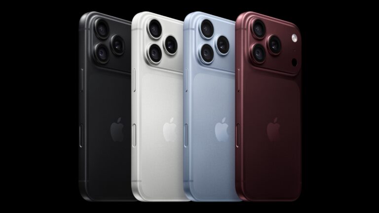 Four iPhones seen from the back in black, white, light blue and burgundy, each with a triple-lens camera bump, on a black background.